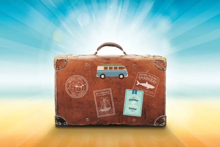 valise vintage marron avec autocollants de voyage sur fond de plage ensoleillée