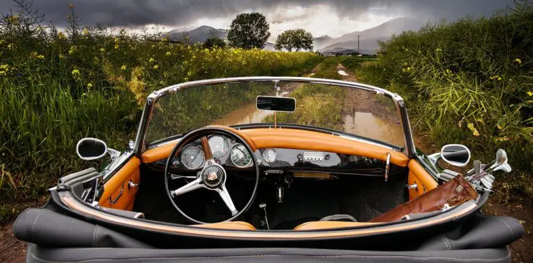 cabriolet vintage orange avec intérieur cuir dans paysage rural montagneux