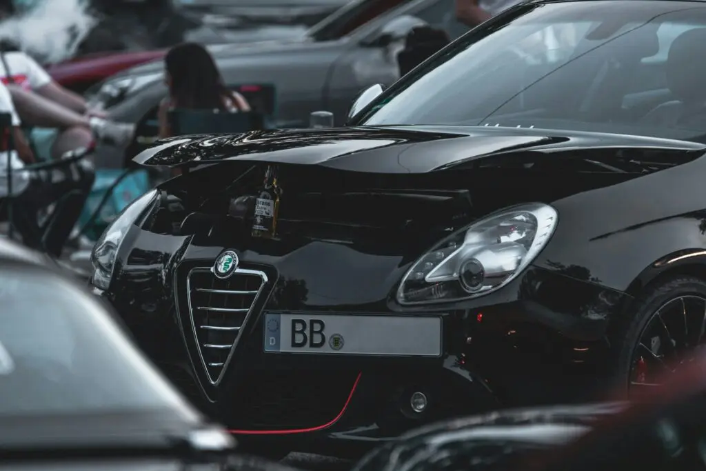 alfa romeo noire garée avec logo visible sur le grille avant