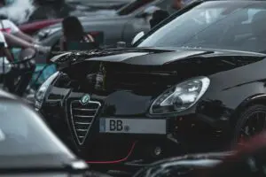 alfa romeo noire garée avec logo visible sur le grille avant