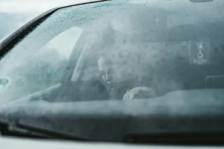 conducteur derrière un pare-brise embuée et mouillé