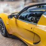 lotus jaune décapotable avec portière ouverte, volant visible à l'intérieur