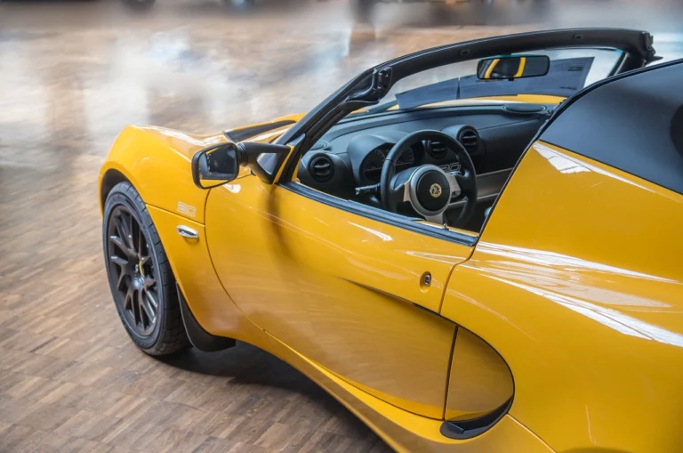 lotus jaune décapotable avec portière ouverte, volant visible à l'intérieur
