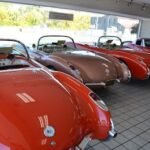 a row of classic sports cars in a showroom