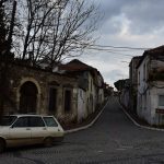 A vintage station wagon parked on a cobblestone street.