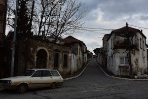 A vintage station wagon parked on a cobblestone street.