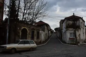A vintage station wagon parked on a cobblestone street.